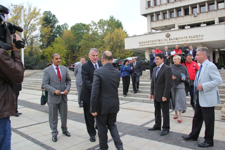 a group of men and women walking into a building