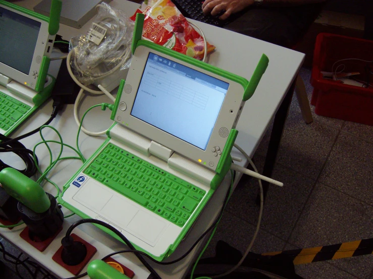 a desk with two laptops and various wires connected