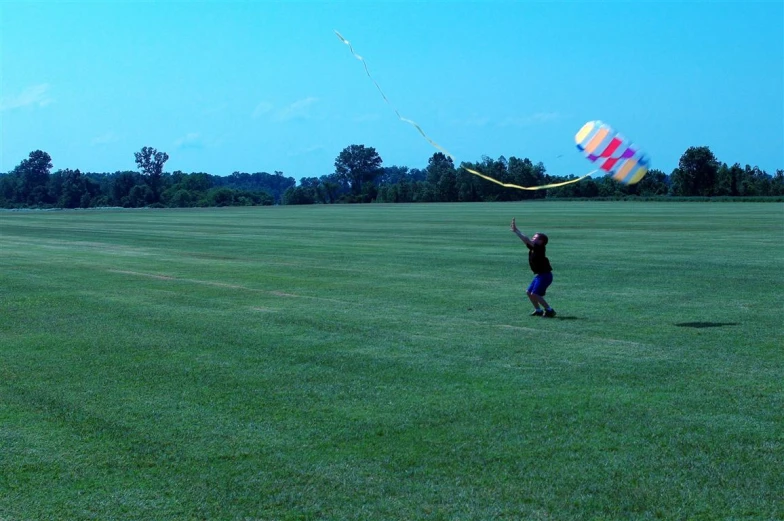 a child is flying a kite on a sunny day