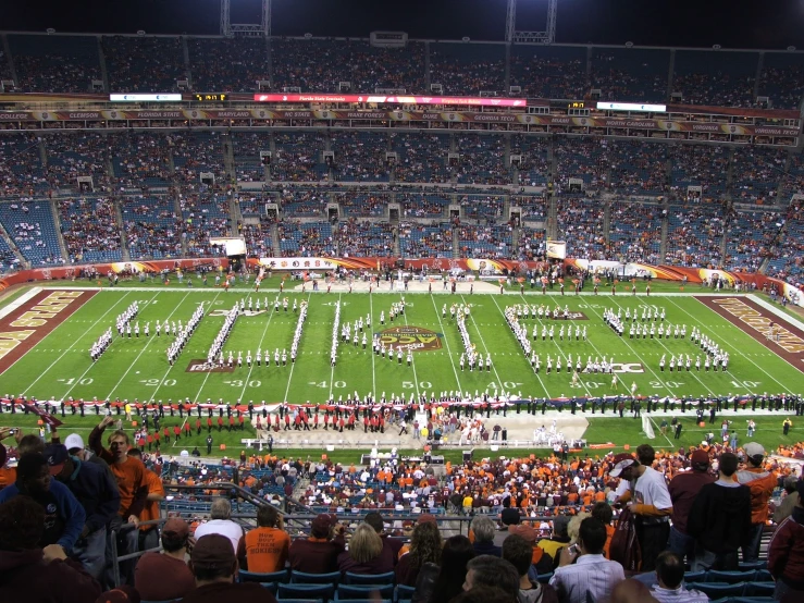 an university football field full of fans and band