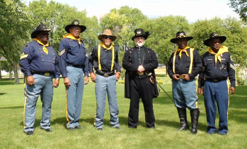 a group of civil war re - enactors standing in front of trees