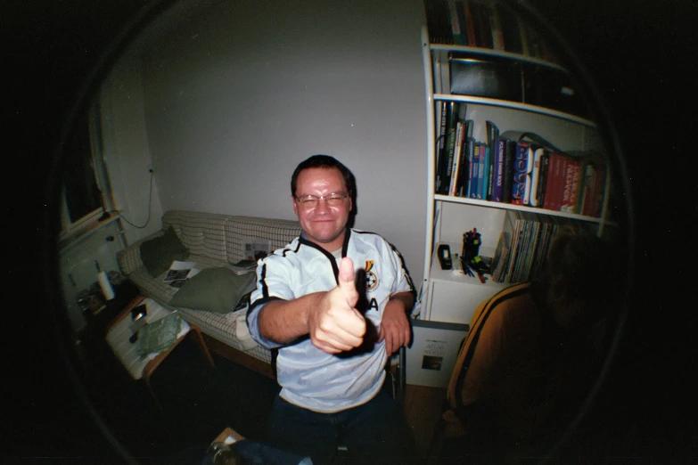 man gives thumbs up to the camera with beer