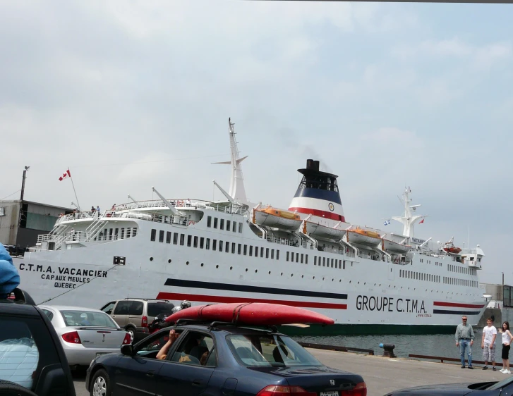 a ship in the harbor with a man walking nearby