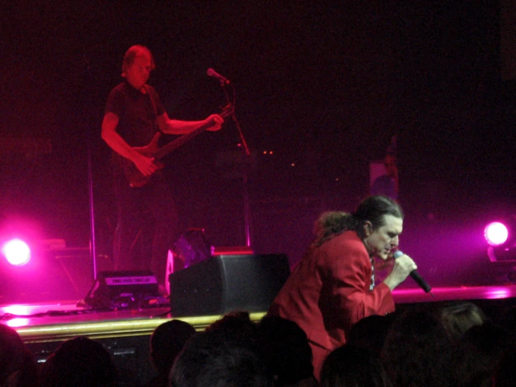 people at a concert in front of red lit spotlights