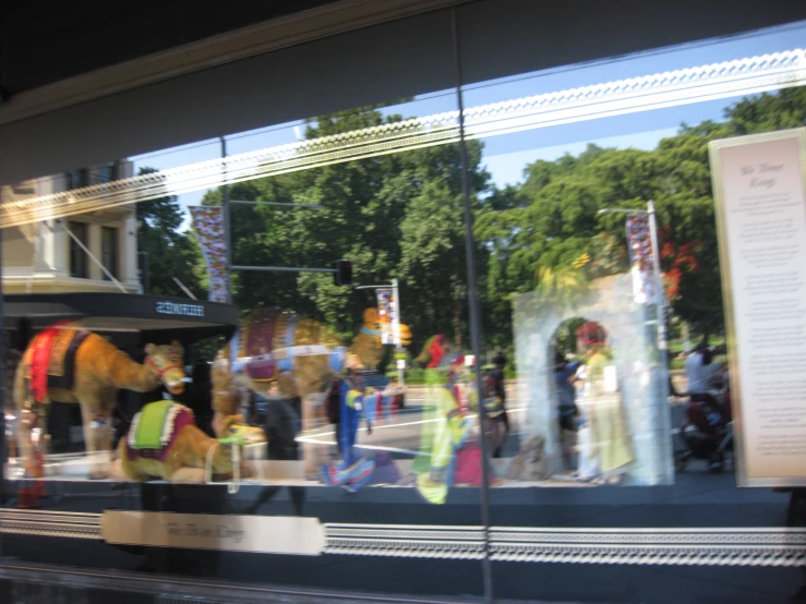 a couple of horses and people standing behind a glass window