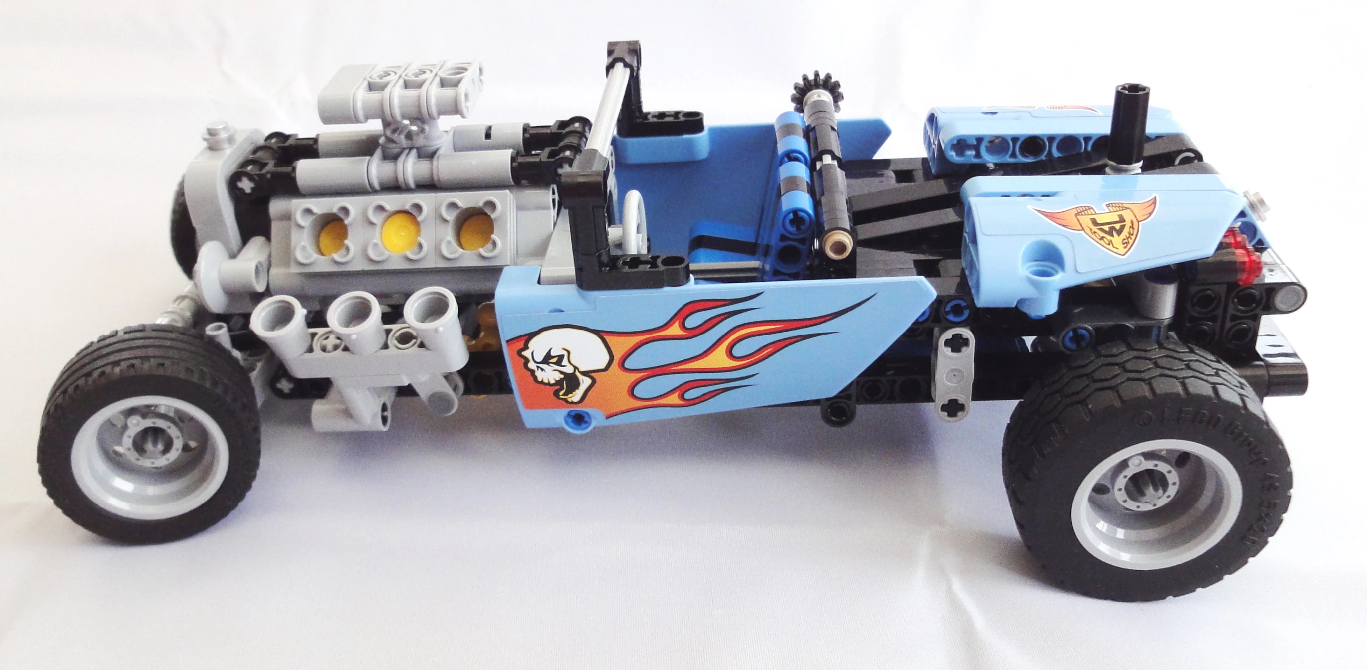 a toy truck with two large tires and flames on it