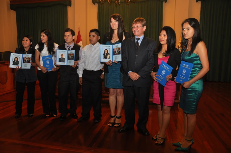 a man and a group of people standing in a room with portraits