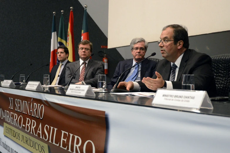 a meeting room with several people sitting at a long table