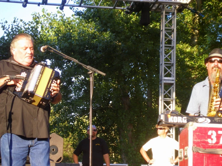 two men playing instruments and singing into microphones