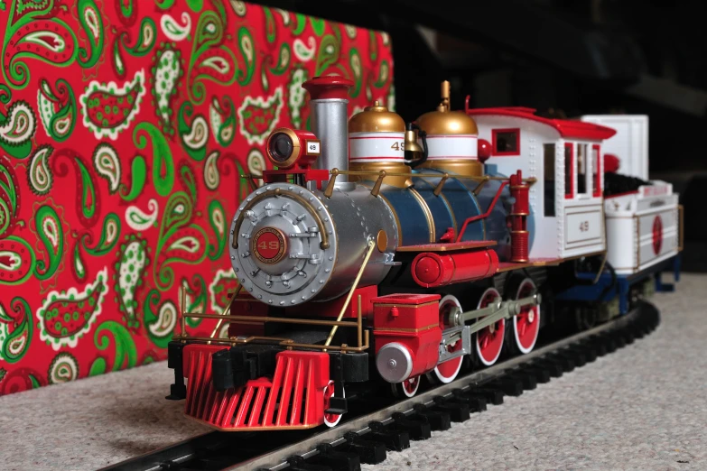 a miniature train engine with christmas ornaments on top