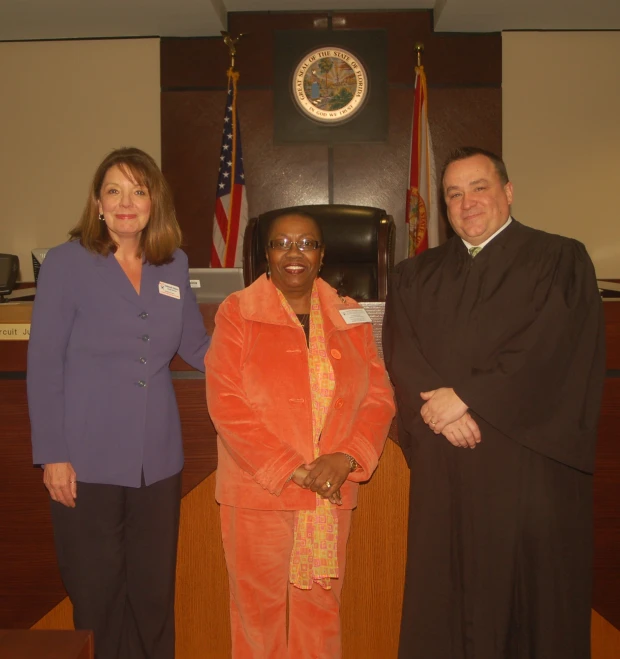 a man in a courtroom suit and a judge with two women