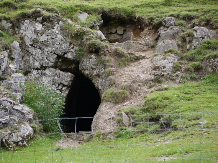 there is a hole in the mountains near the grass