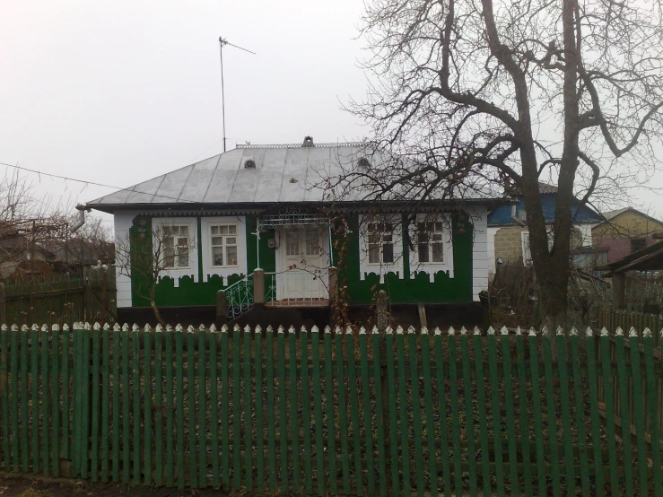 a wooden fence surrounds the yard of a white cottage