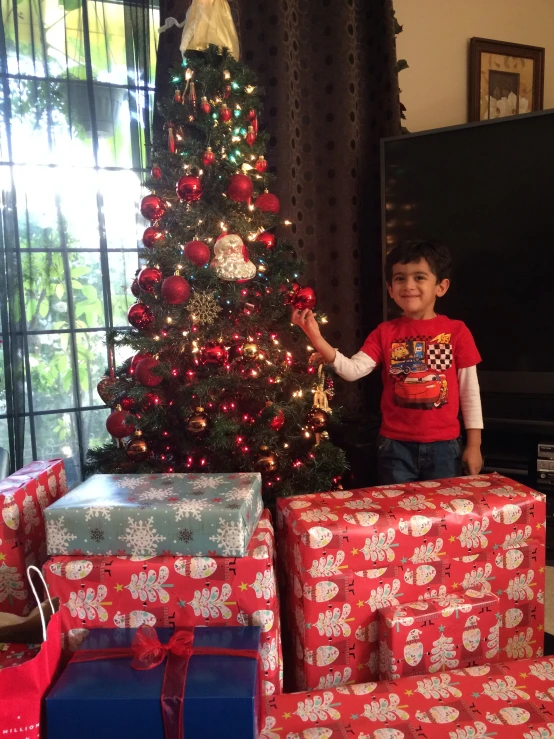 a boy is standing in front of presents