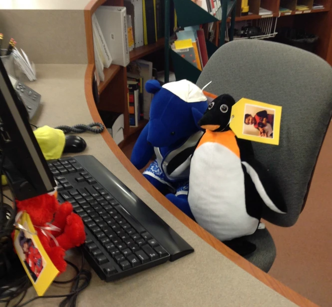 a stuffed penguin and penguin hat on a chair