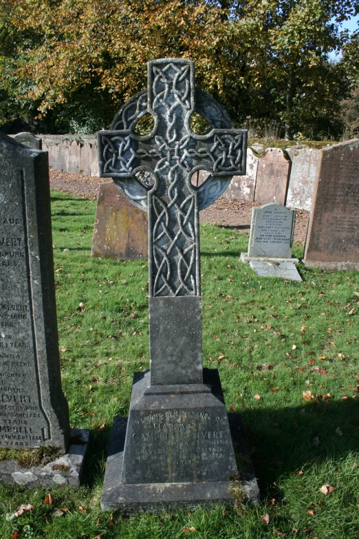 an old cemetery with two headstones and a cross on one of them