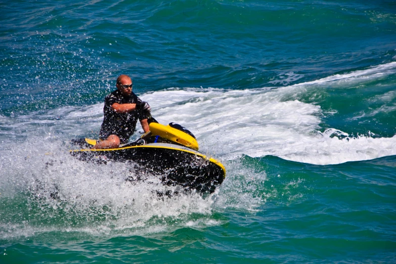 a man on a yellow and black jet ski in the water