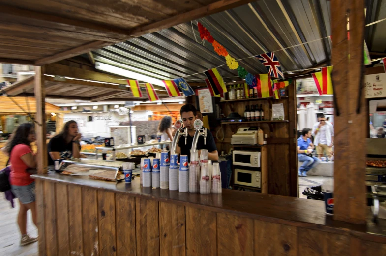 a food market with several food vendors working in the kitchen