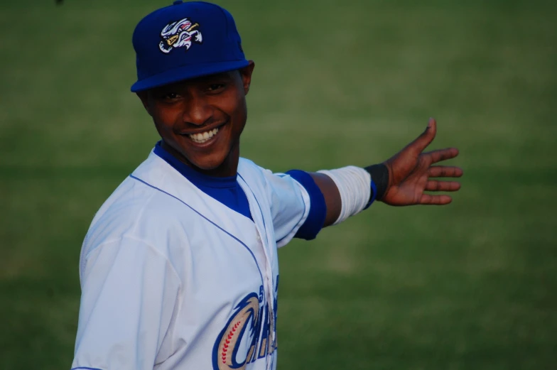 a baseball player smiling and giving the peace sign