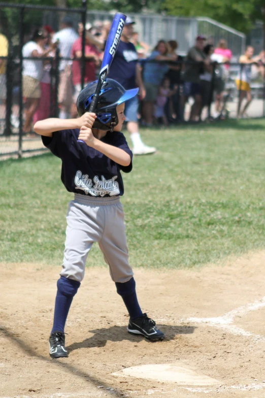 a small child holding a baseball bat on the field