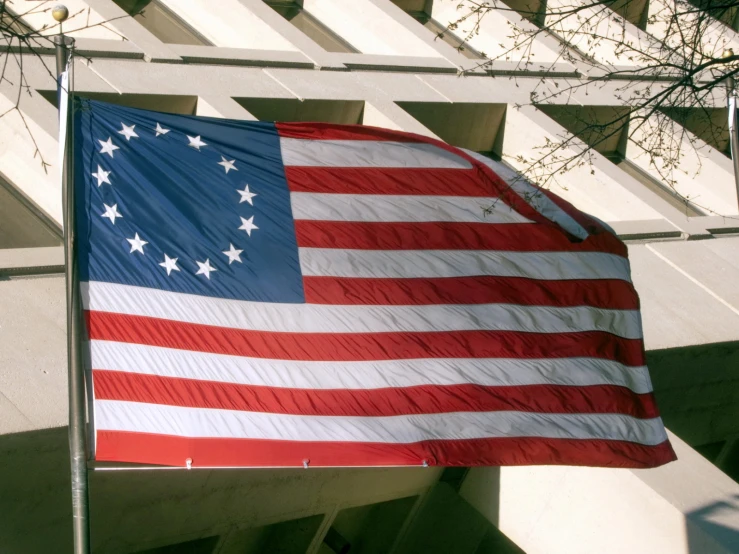 an american flag on a pole in front of some building