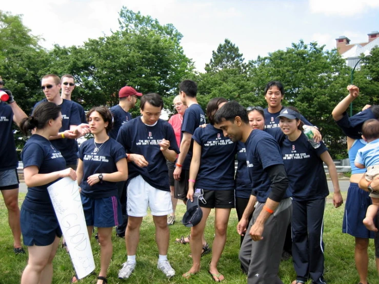 many people are standing together holding kites