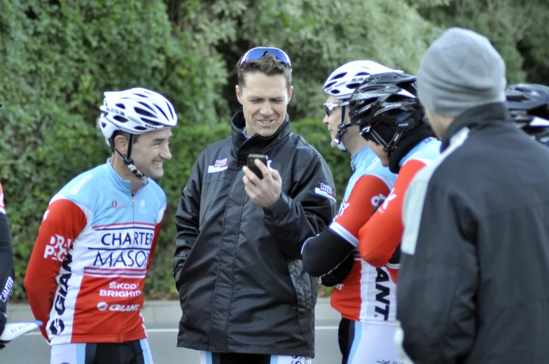 there are men in bicycle helmets and bikes talking to each other