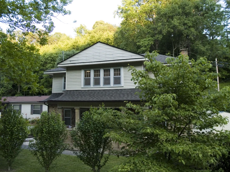 a white house surrounded by trees and landscaping