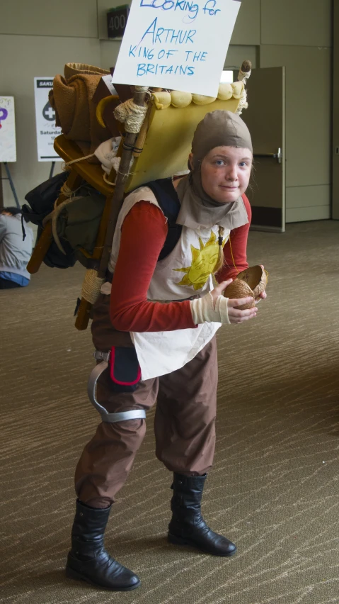 a child dressed as a costume holding up a cookie