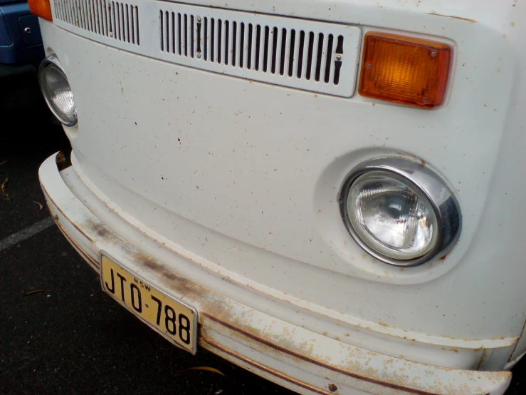 a white vw bus sitting next to a blue truck