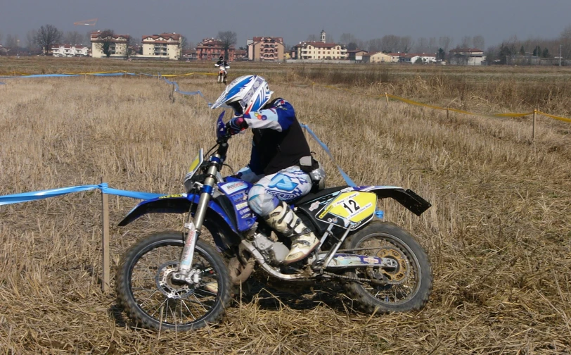a man on a dirt bike parked near blue tape