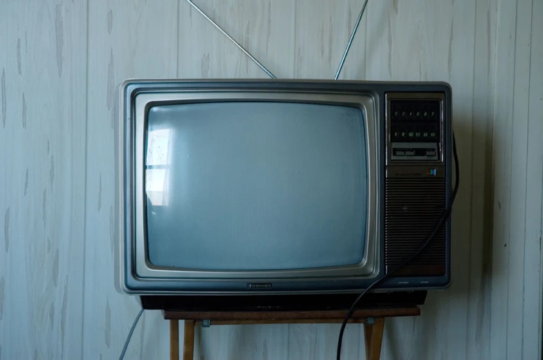 an old television is sitting on a table with wires