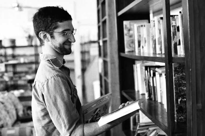 a man that is standing in front of a book shelf