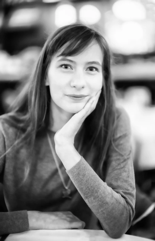 a woman sitting at a table smiling