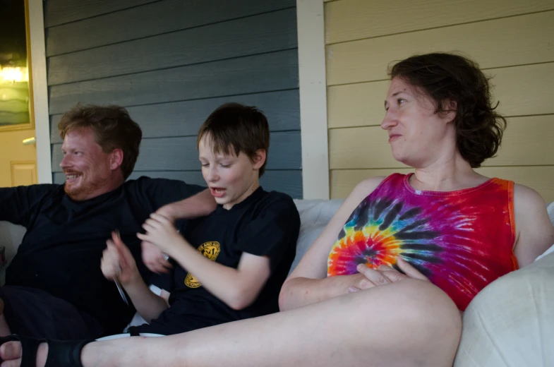 two adults and a child sitting together on a couch