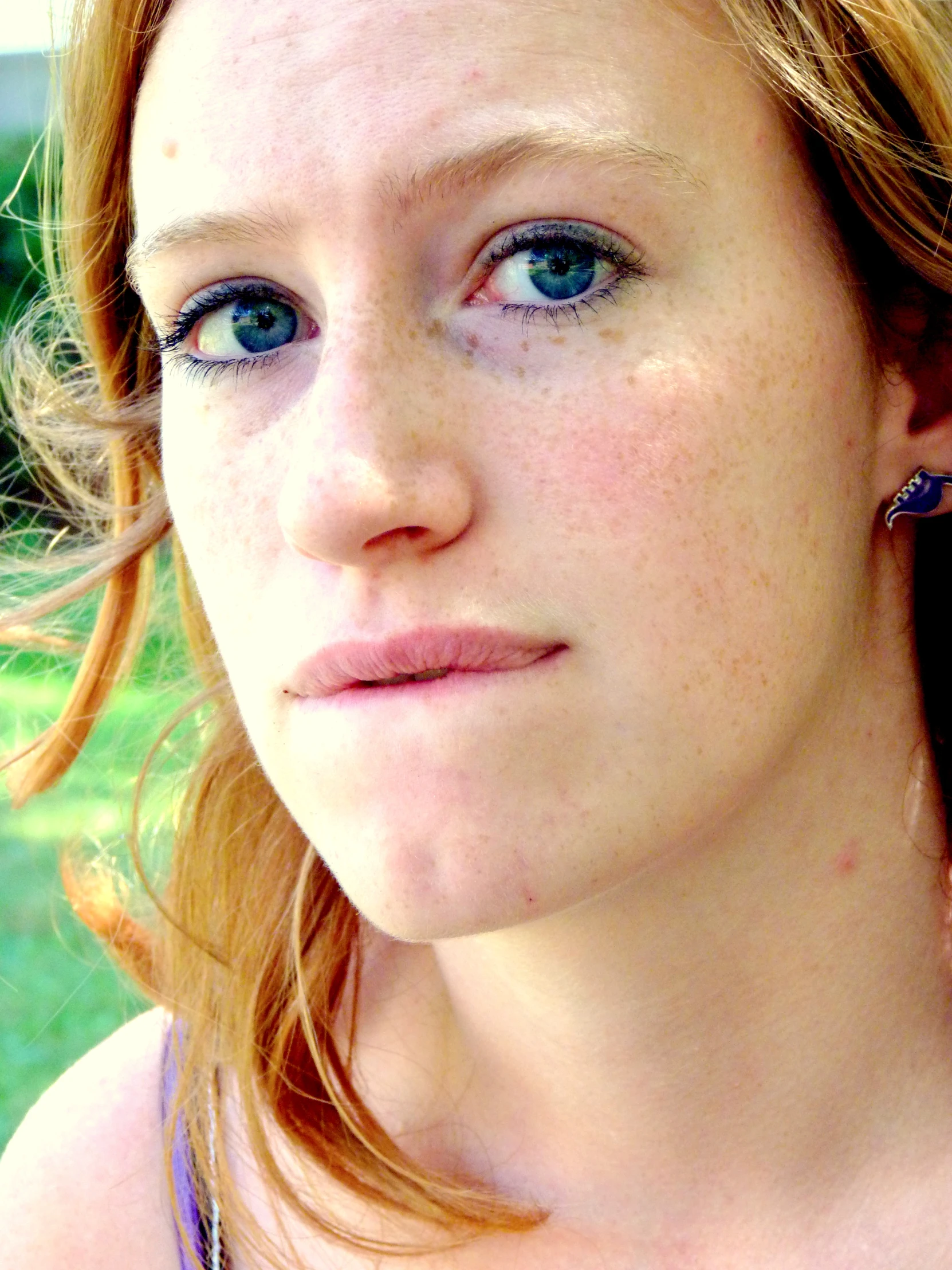 a beautiful young woman wearing blue earrings on top of her head