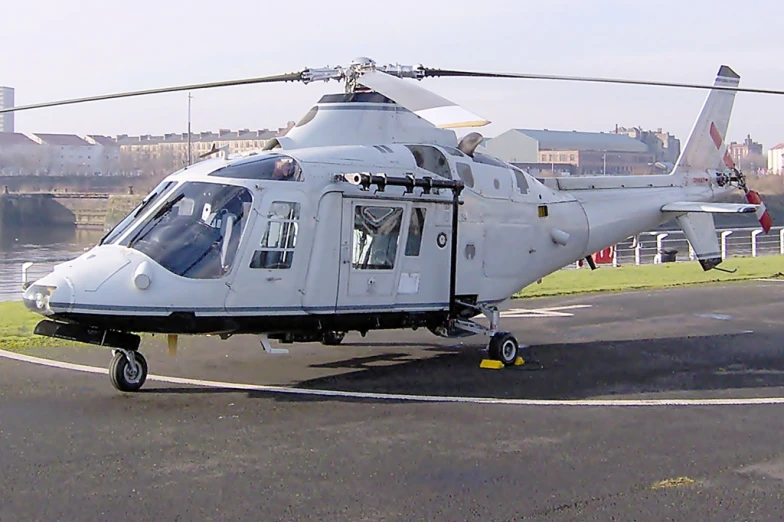 a white helicopter sits on the runway and ready to depart