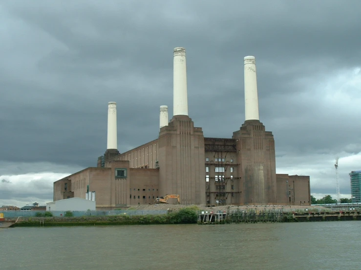 a factory building along the water and some boats