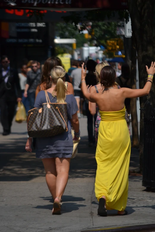 two woman walking down the street while holding hands