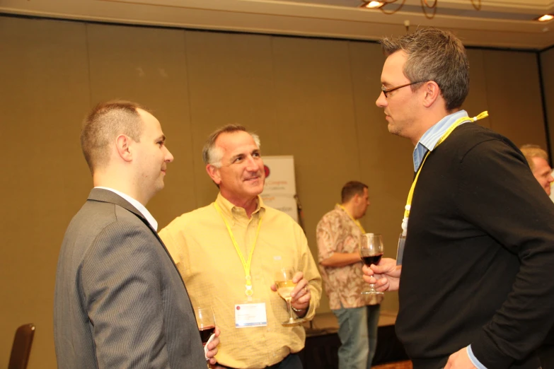 some men are talking and drinking at an event