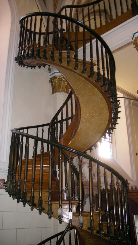 a spiral staircase inside of a home with a white wall
