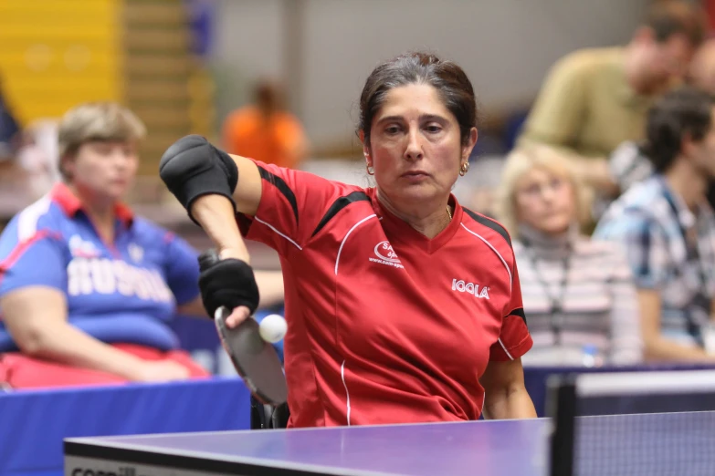 the women in the red shirt is playing ping pong