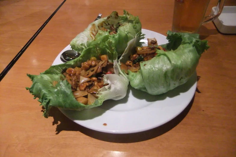 a plate topped with lettuce wrapped in lettuce and sauce