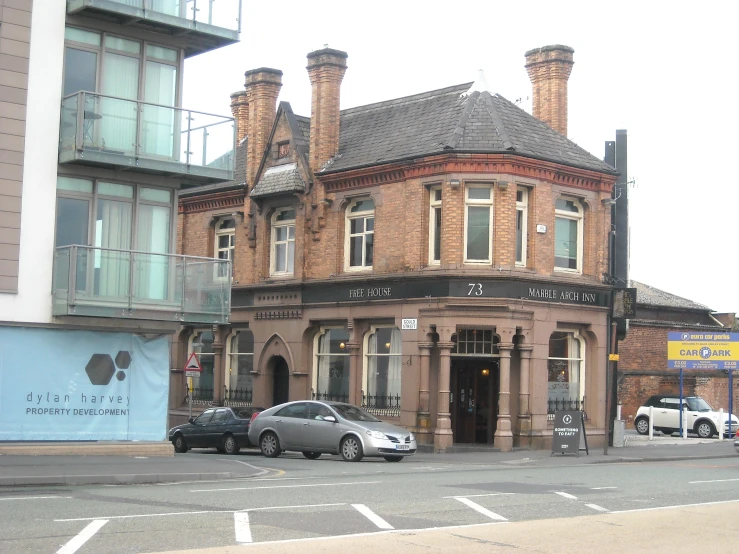 the corner building has two cars parked outside