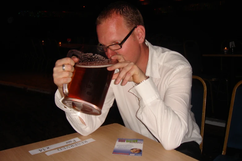 a man sitting at a table eating a large piece of food