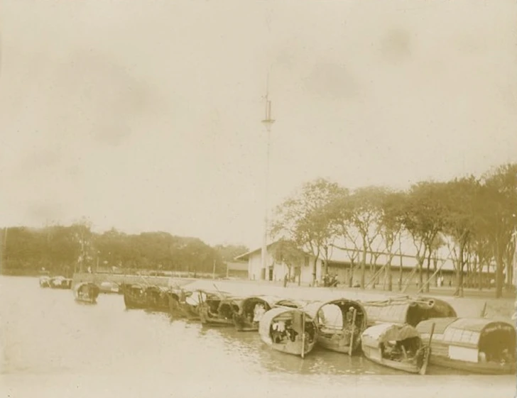 boats sitting in the water next to a tower