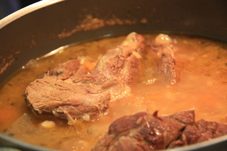 some cooked meat cooking in a pot of soup