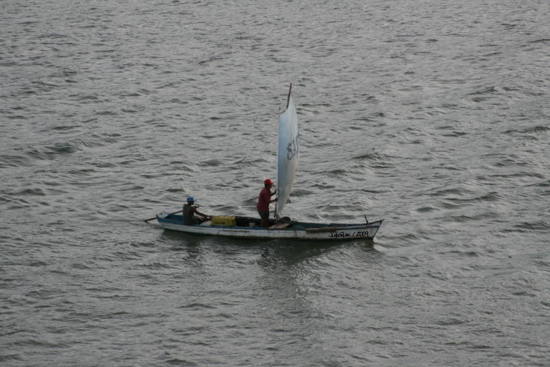 a boat with a white sail in the ocean