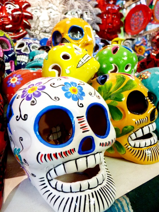 several colorful skull heads sit on display in a store