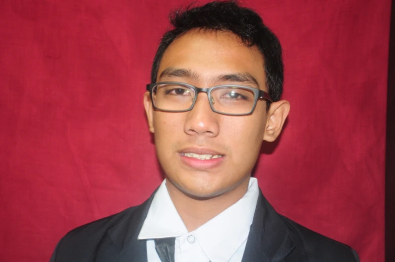 a young man in glasses and suit jacket